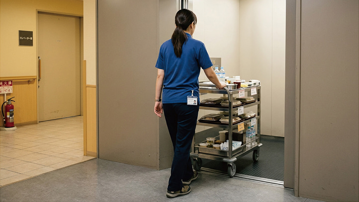 配膳車と人が同時にエレベーターに乗る様子
